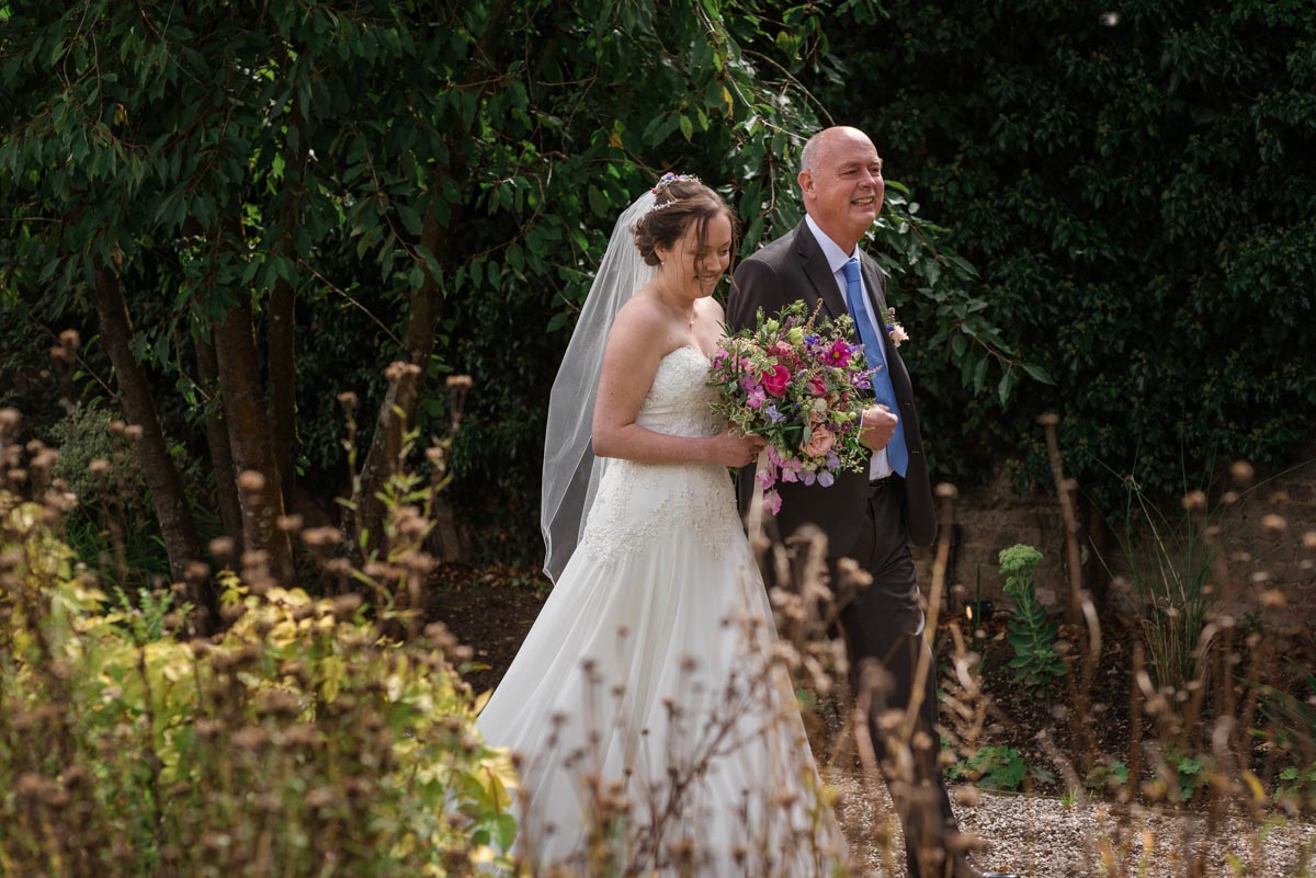 sarah is escorted to her Secret Garden wedding by her dad