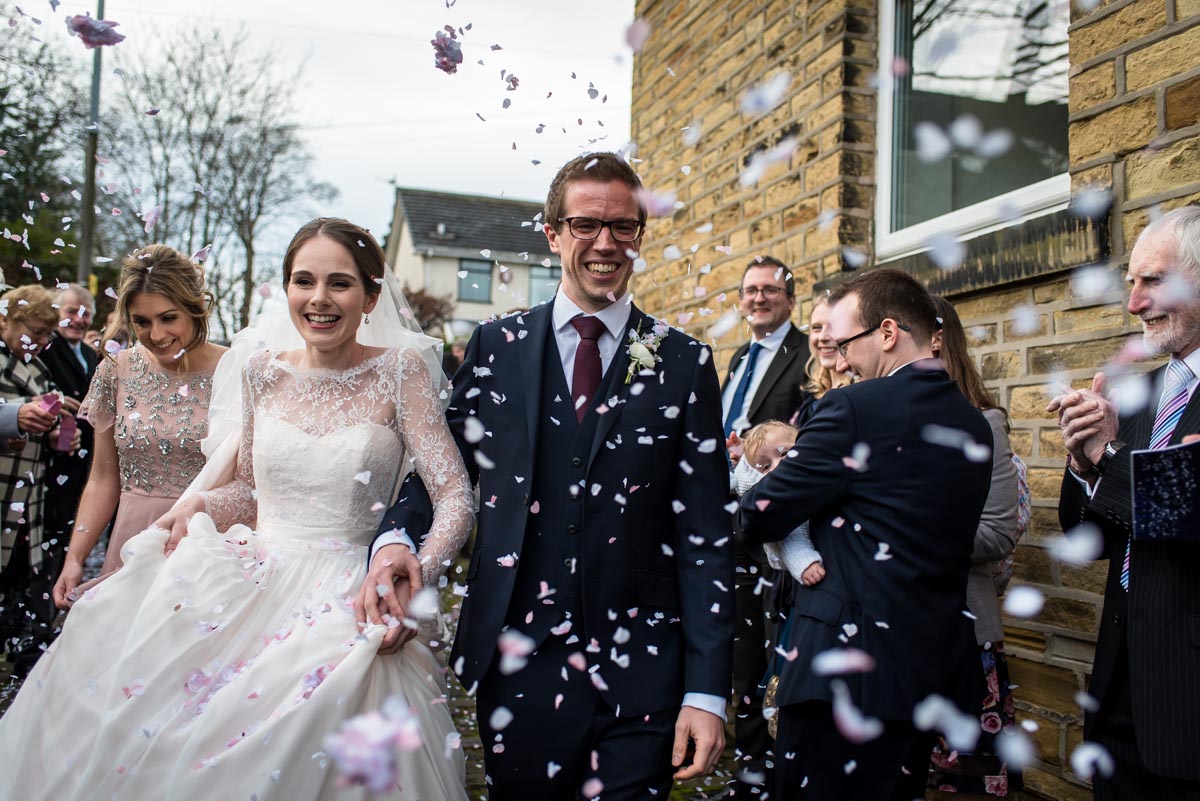 Katherine and Tom are photographed having confetti thrown on them after their Yorkshire wedding