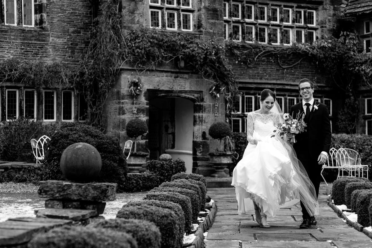 Tom and Katherine photographed walking down path outside Holdsworth House on their wedding day