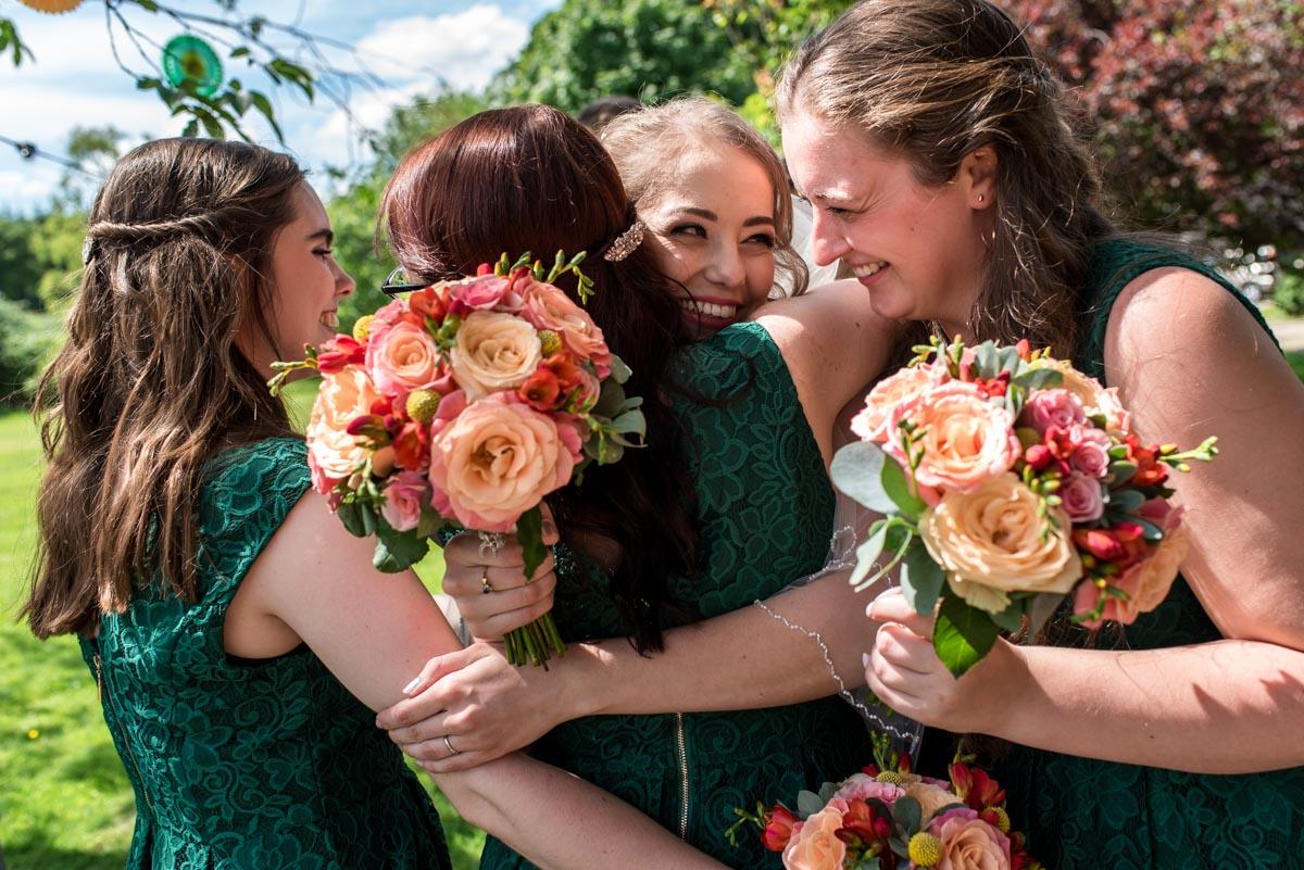 bride receives hugs of congratulations from bridesmaids