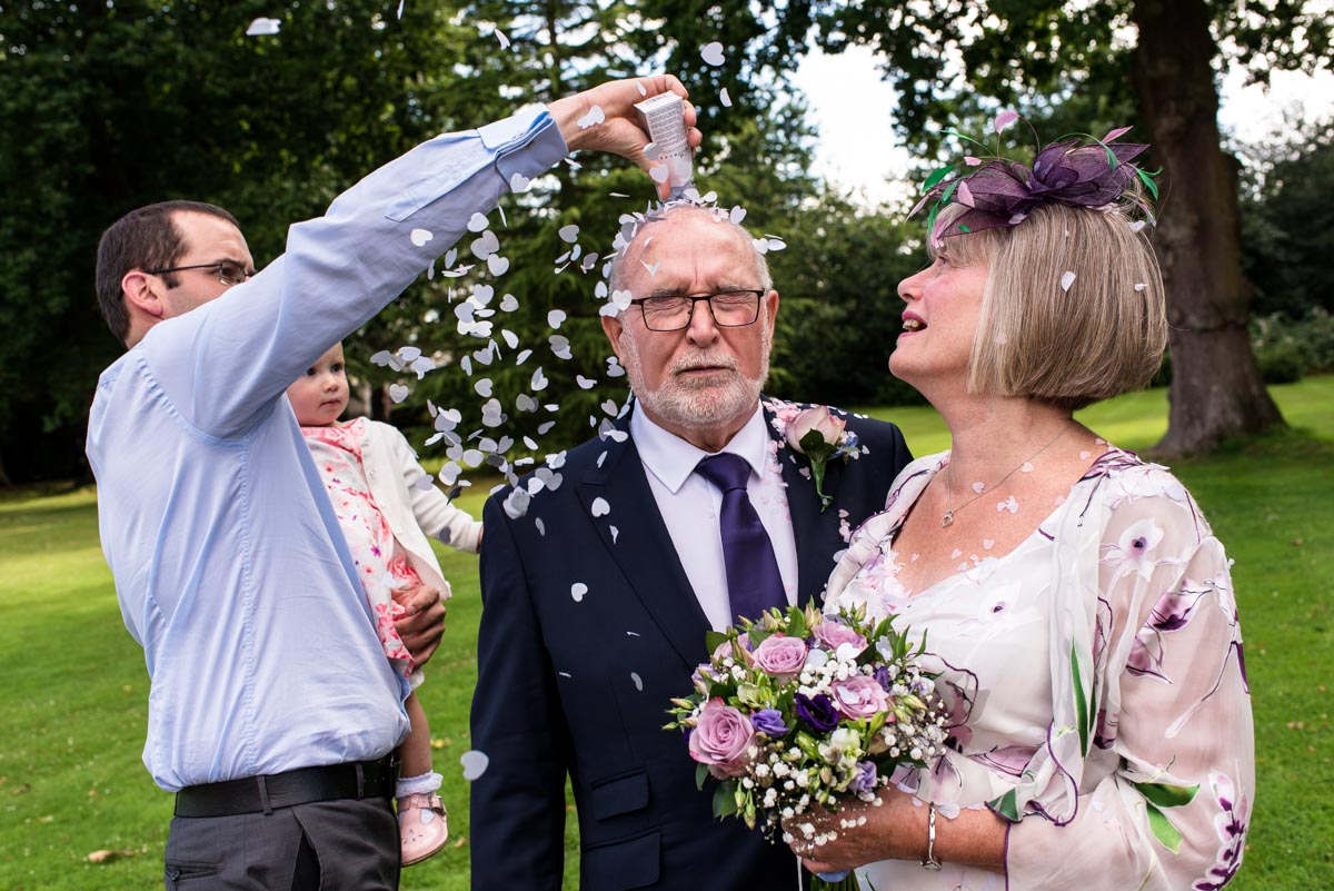 Confetti thrown on grooms head after ceremony