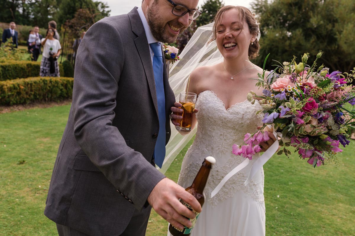Couple enjoying a drink after their wedding ceremony at the secret garden in Kent