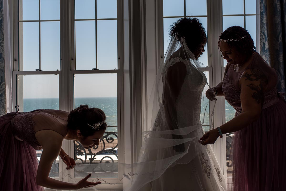 bridesmaids attend to brides veil before her wedding at Hythe Imperial Hotle in kent