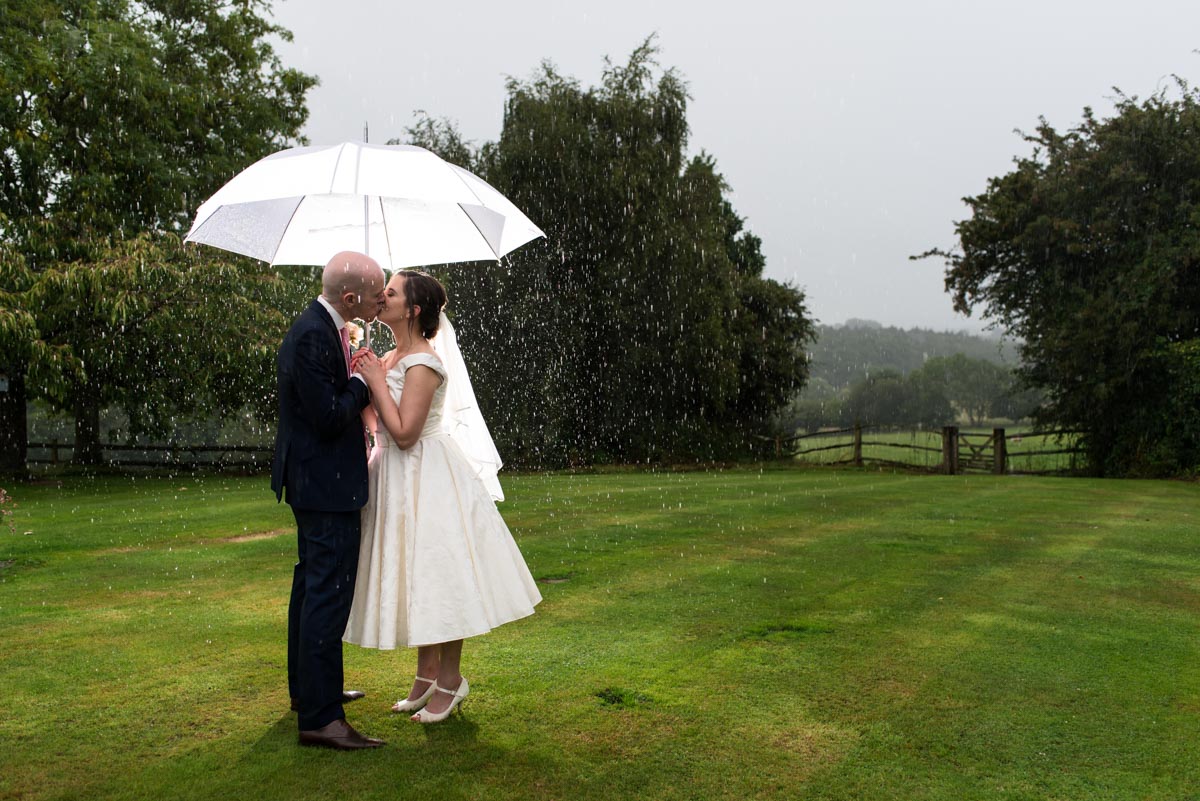 Photograph of wedding couple in the rain
