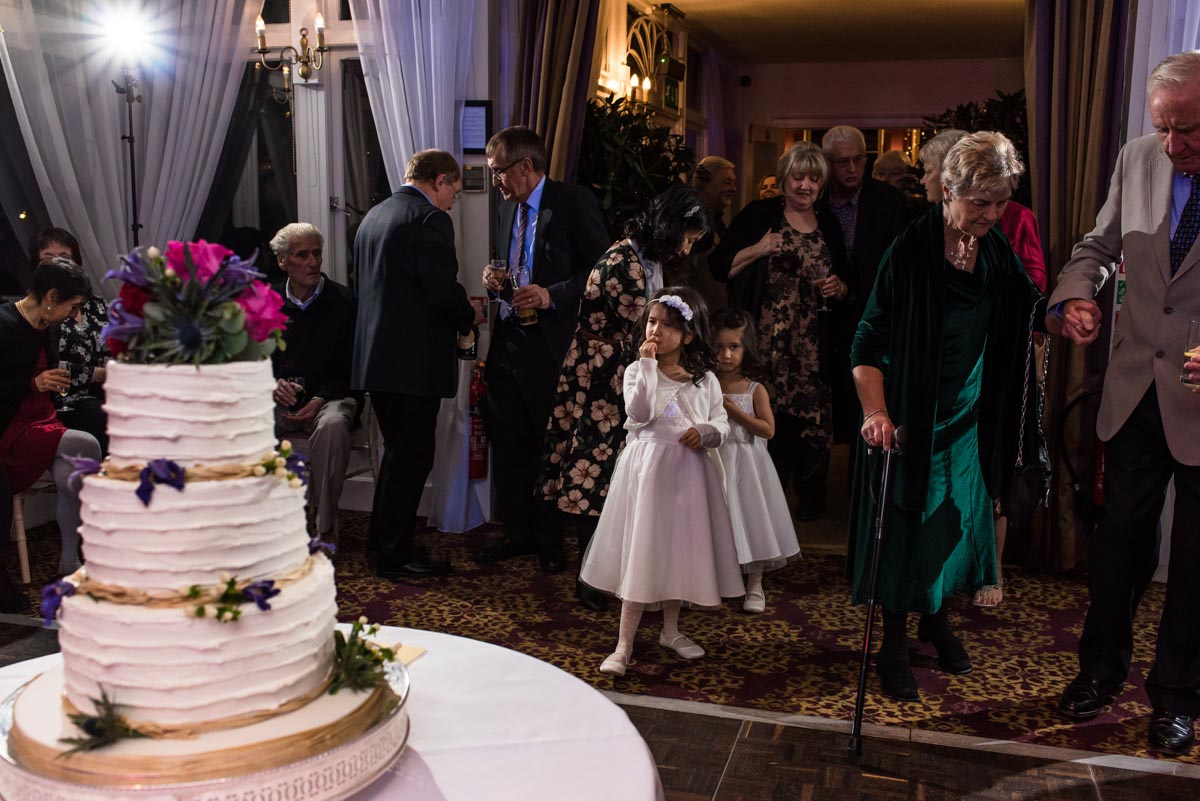 Photograph of flower girls admiring wedidng cake at chilston park hotel in Kent