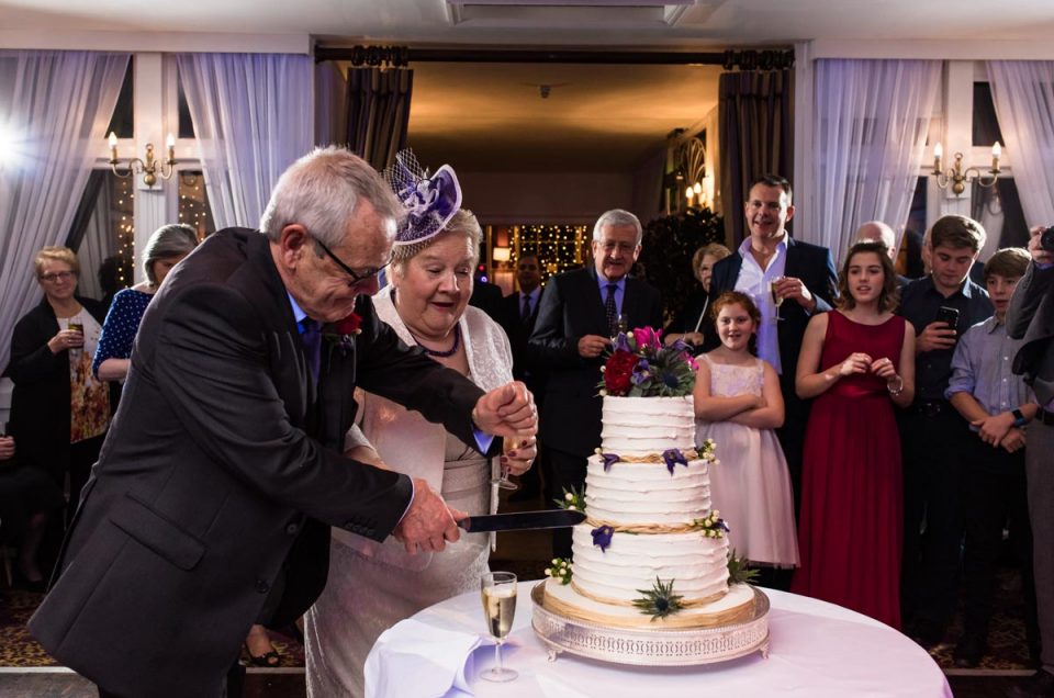 Photograph of Jo and Graham cutting their wedding cake at Chilston park hotel in Kent