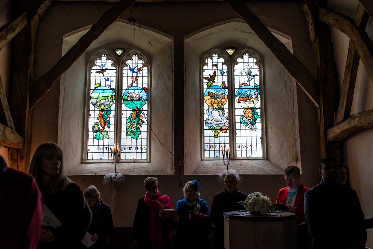 Photograph of wedding guests and stain glass window at St Thomas's church in Kent