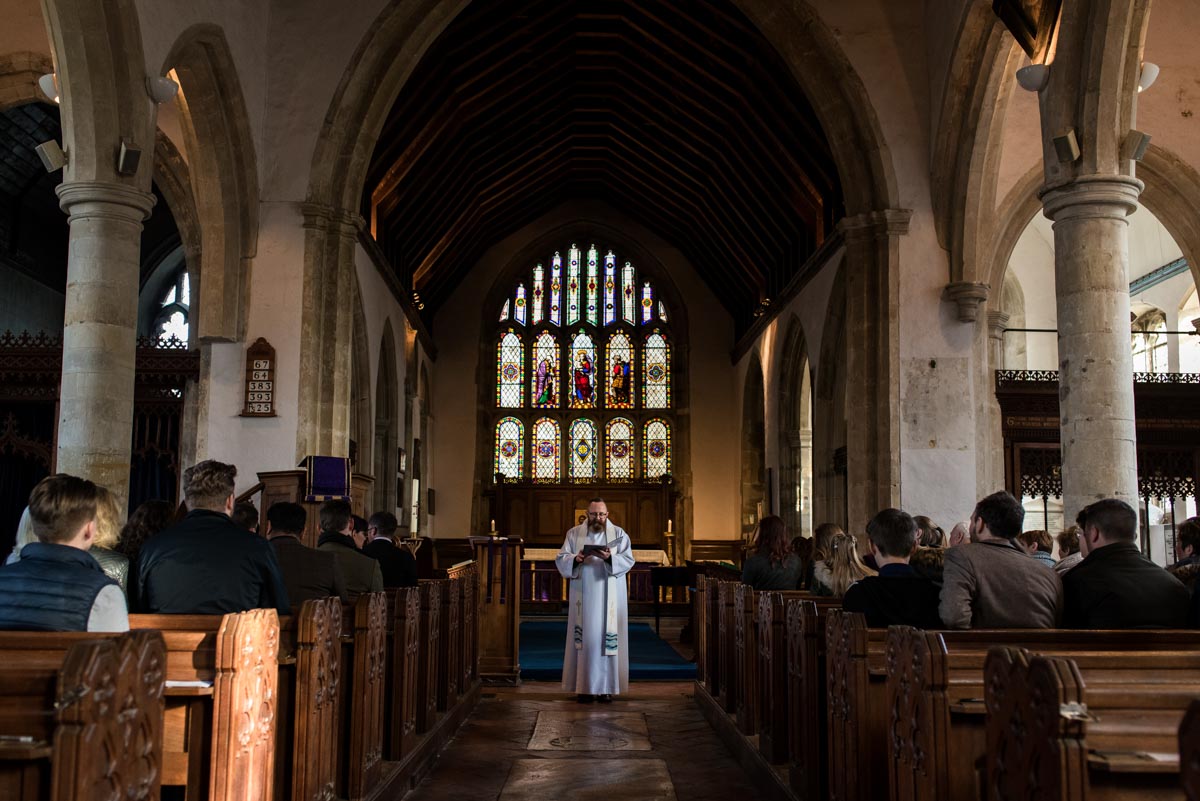 Kent christening photography. The vicar during the service
