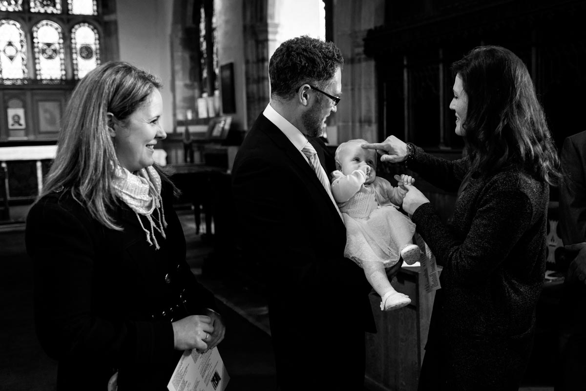 Kent christening photography. Photograph of Godmother and Emily during service