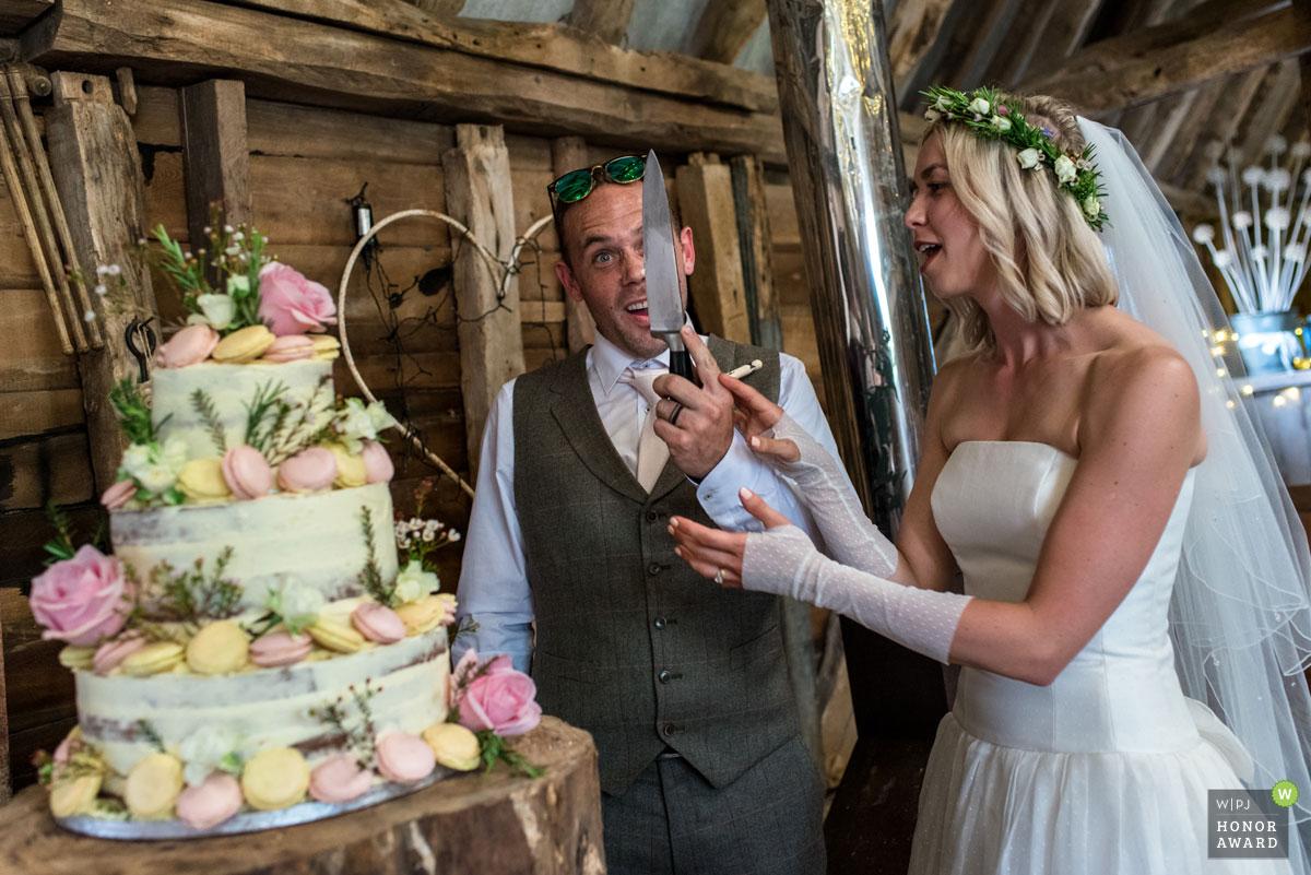 WPJA Honour award winning photo of ann and Josh at their wedding while cutting their cake