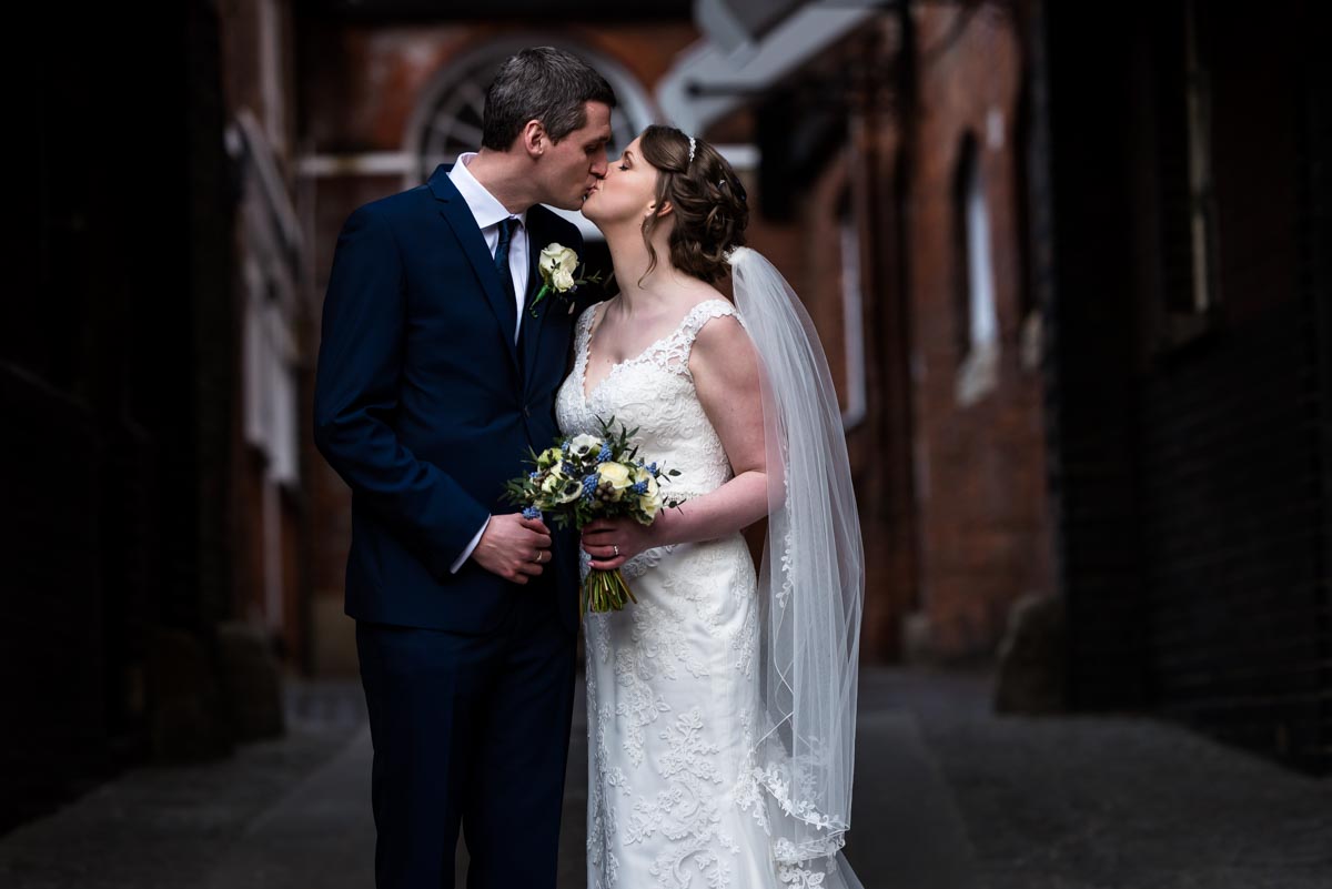 wedding photography portrait of Lindsey and Liam under clock tower at Shepherd Neame brewery
