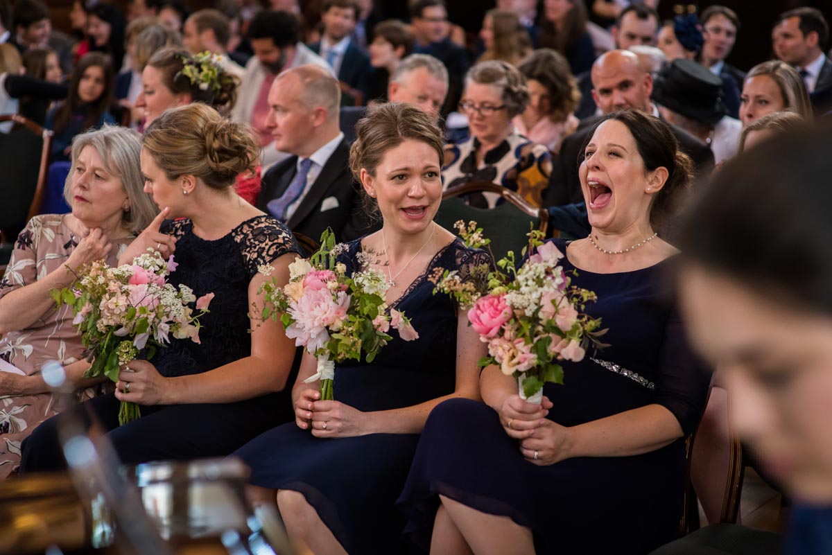Bridesmaids laughing during wedding ceremony at Grays Inn, London
