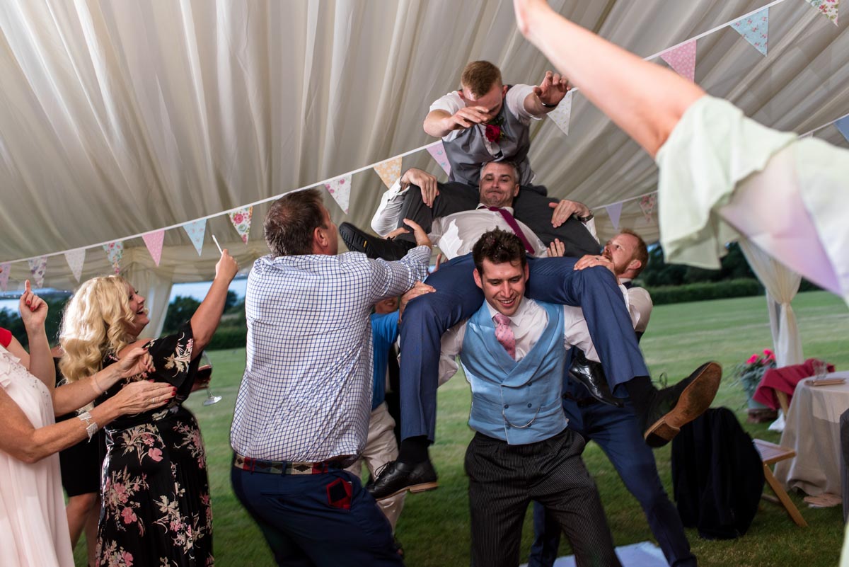 groom and friends messing about at Kent wedding marquee reception