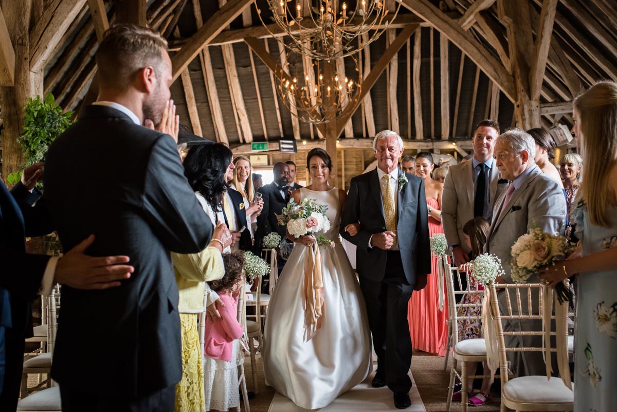 dad and bride walk down the aisle at Odo's Barn wedding in Kent
