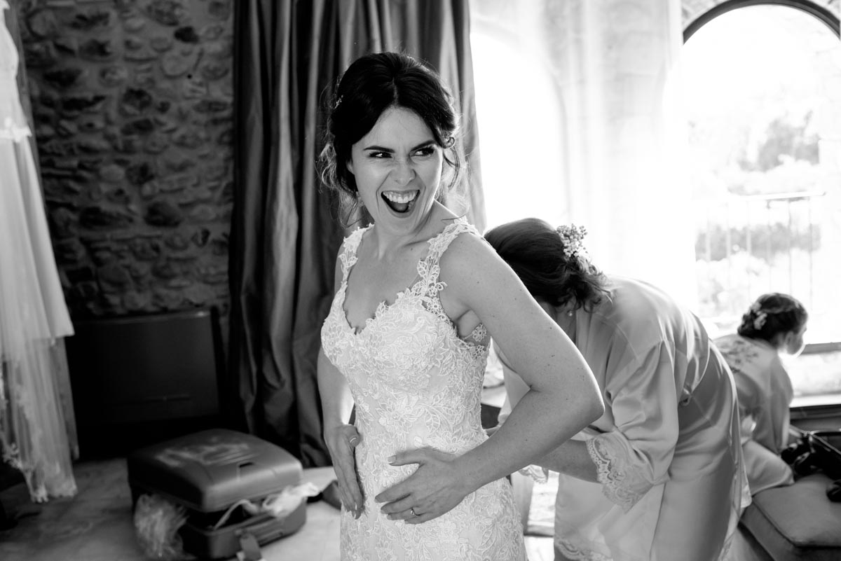 Photograph of a laughing Rebecca as she gets her dress on