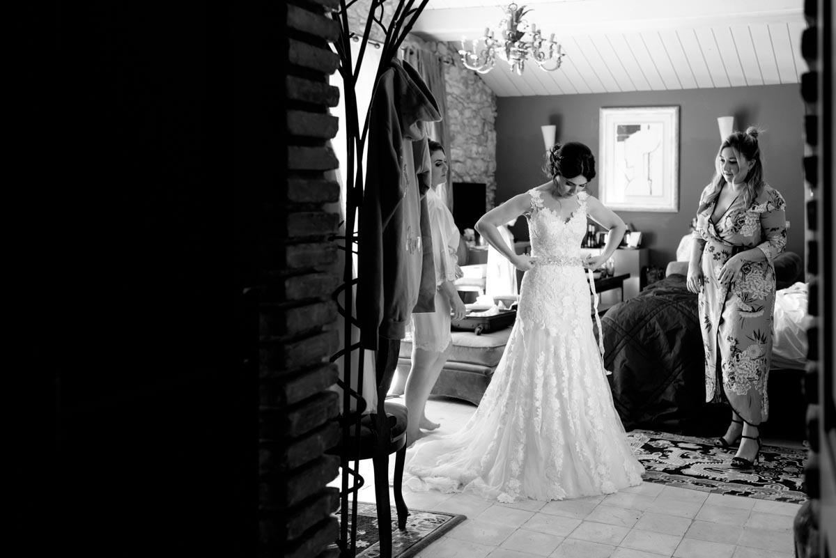 Photograph of Rebecca putting the finishing touches to her wedding dress
