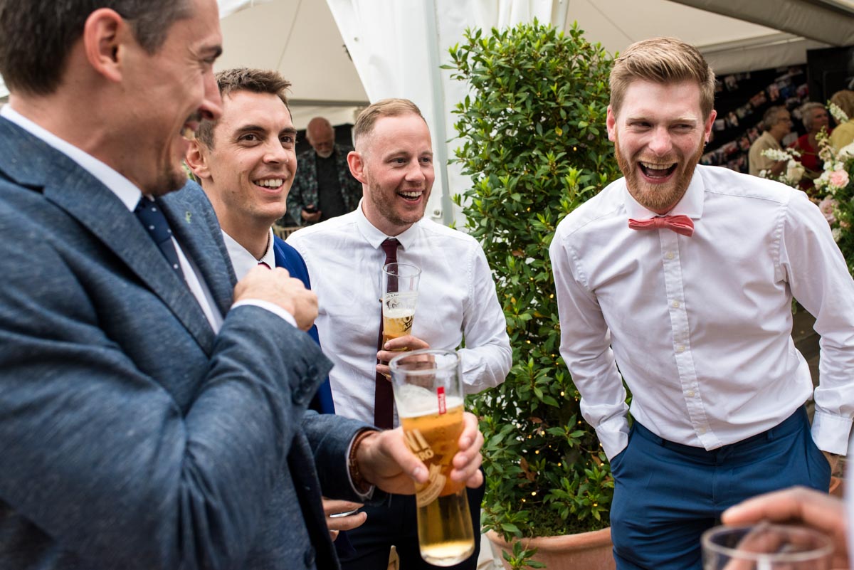 Guests laughing together at Sarah and Craigs wedding at Odo's Barn in Kent