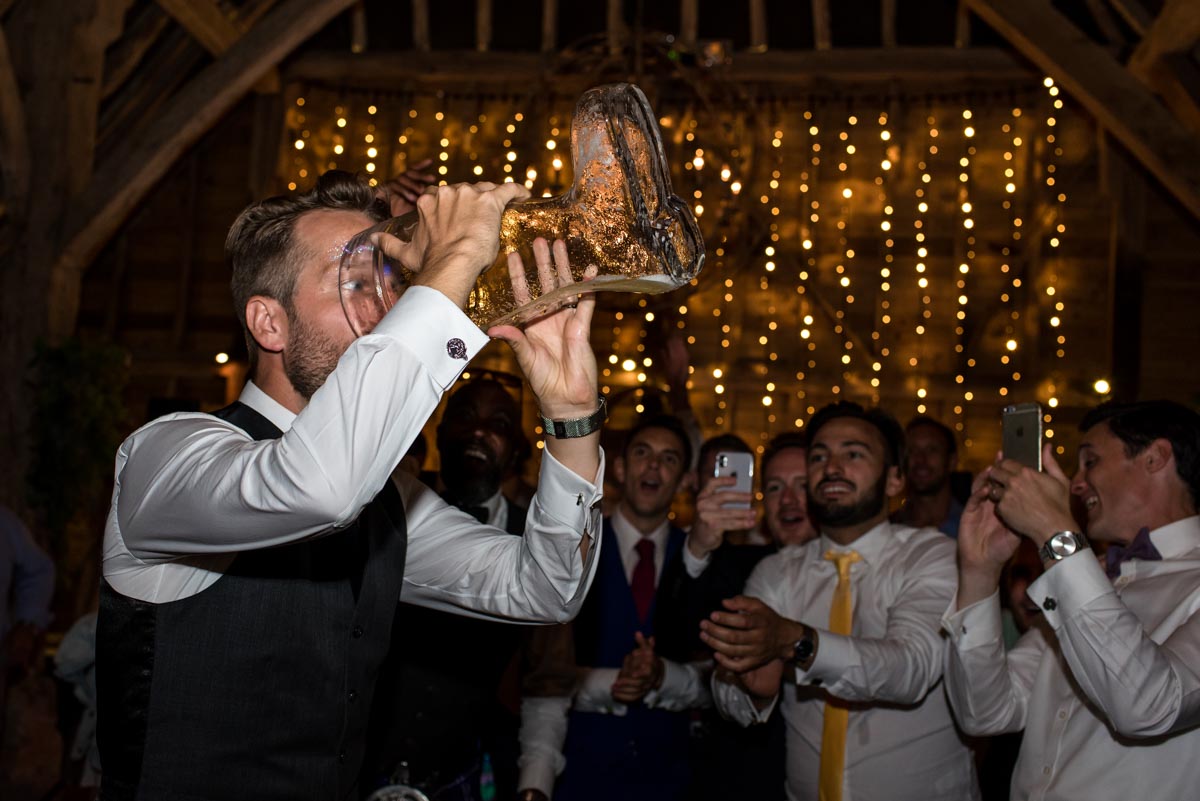 odo's Barn wedding photography, Craig drinks from the beer boot