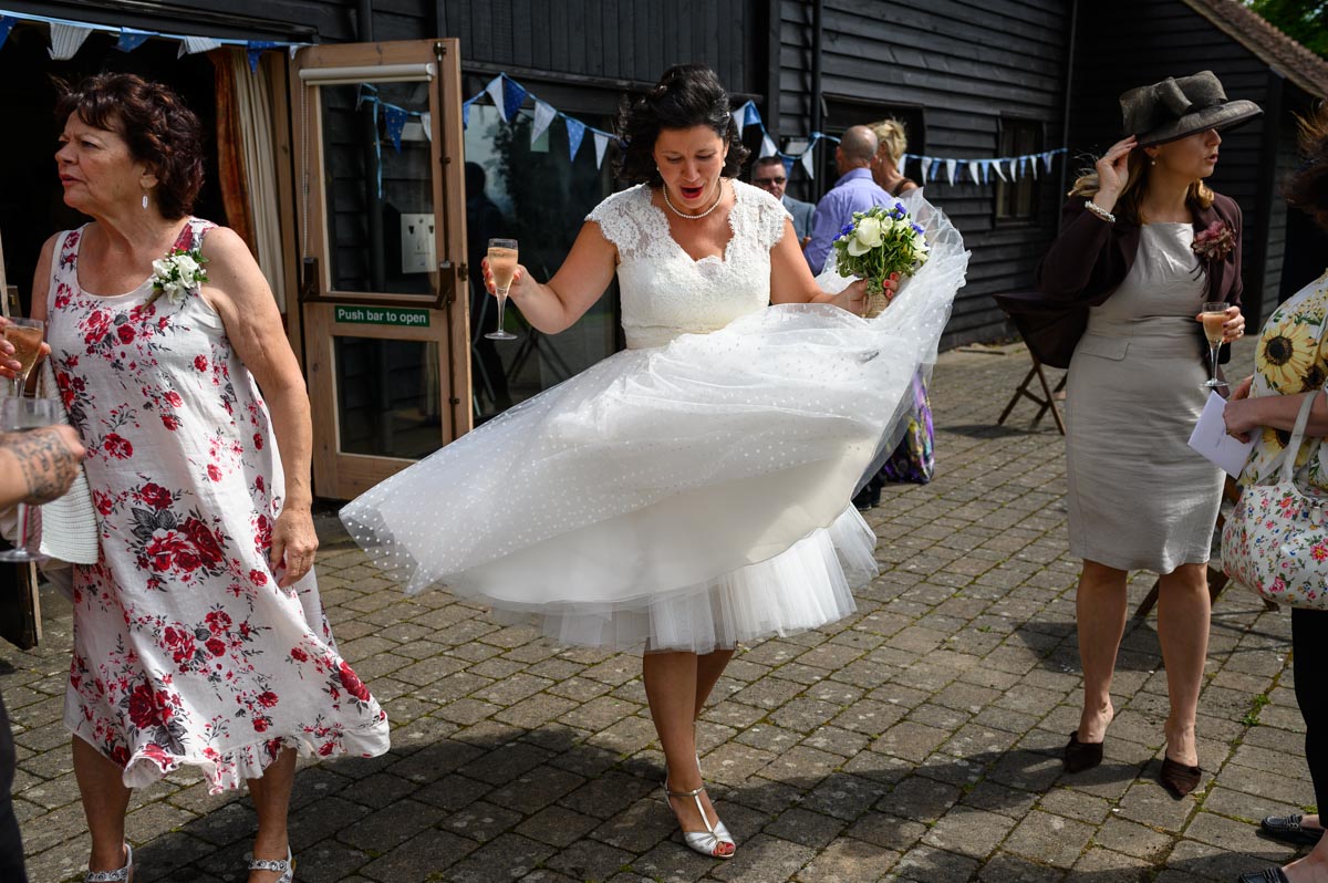 Nathalies wedding dress lifts in the wind during her Kent wedding reception