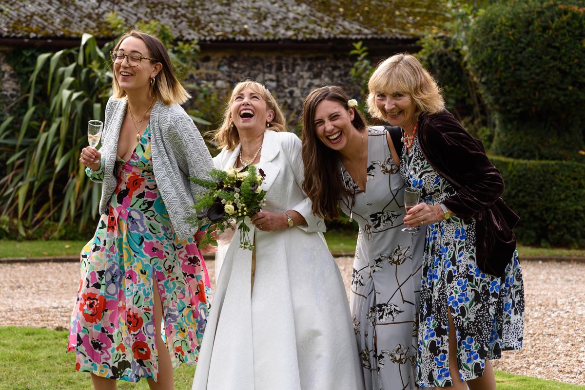 Bride and wedding guests photographed laughing at Solton Manor wedding