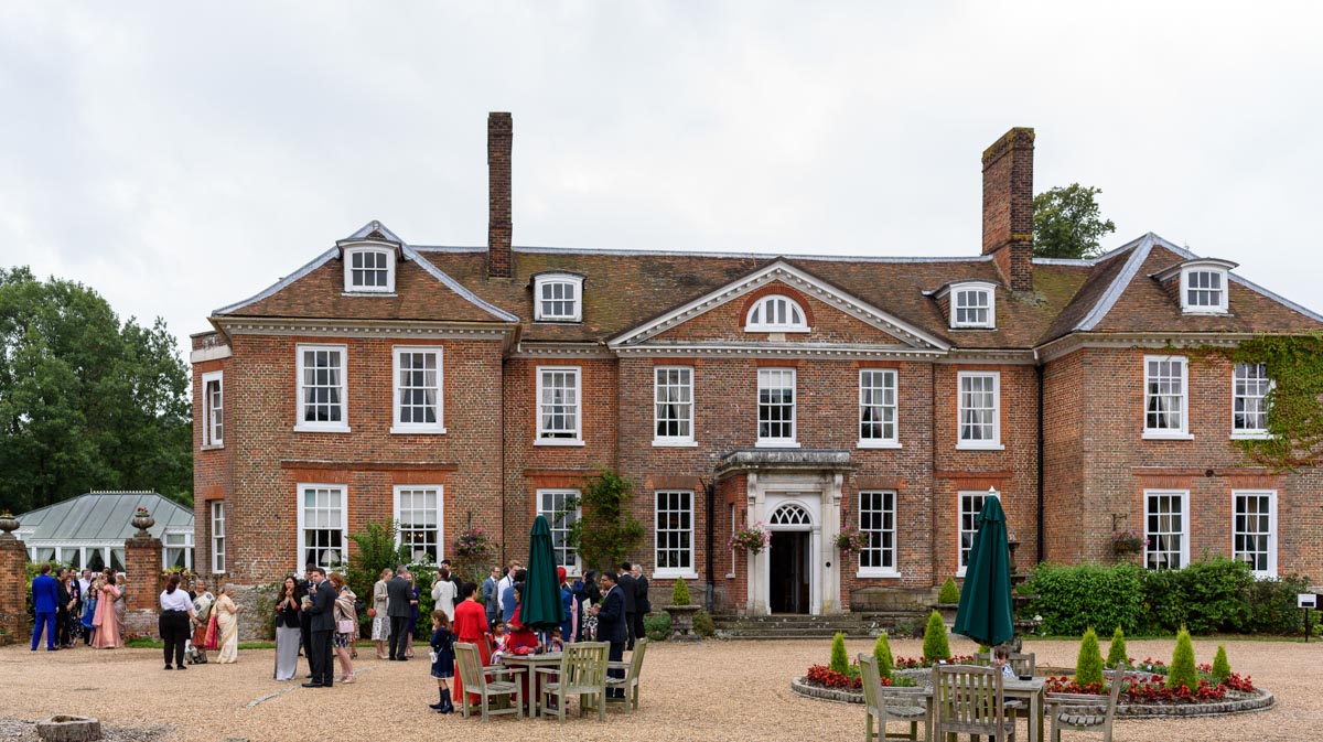 Guests enjoy drinks outside Chilston park hotel during Doug and Vinitas wedding reception