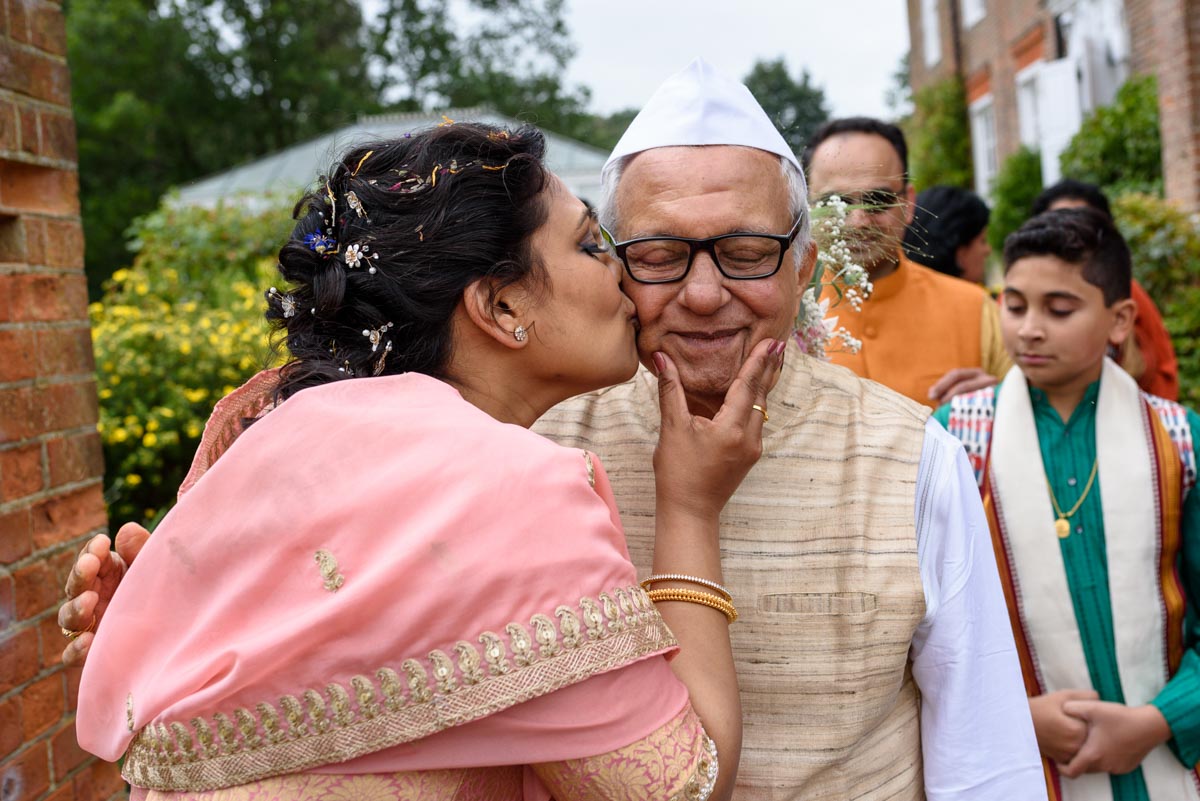 Vinita has a kiss for her father during her Chilston Park wedding reception