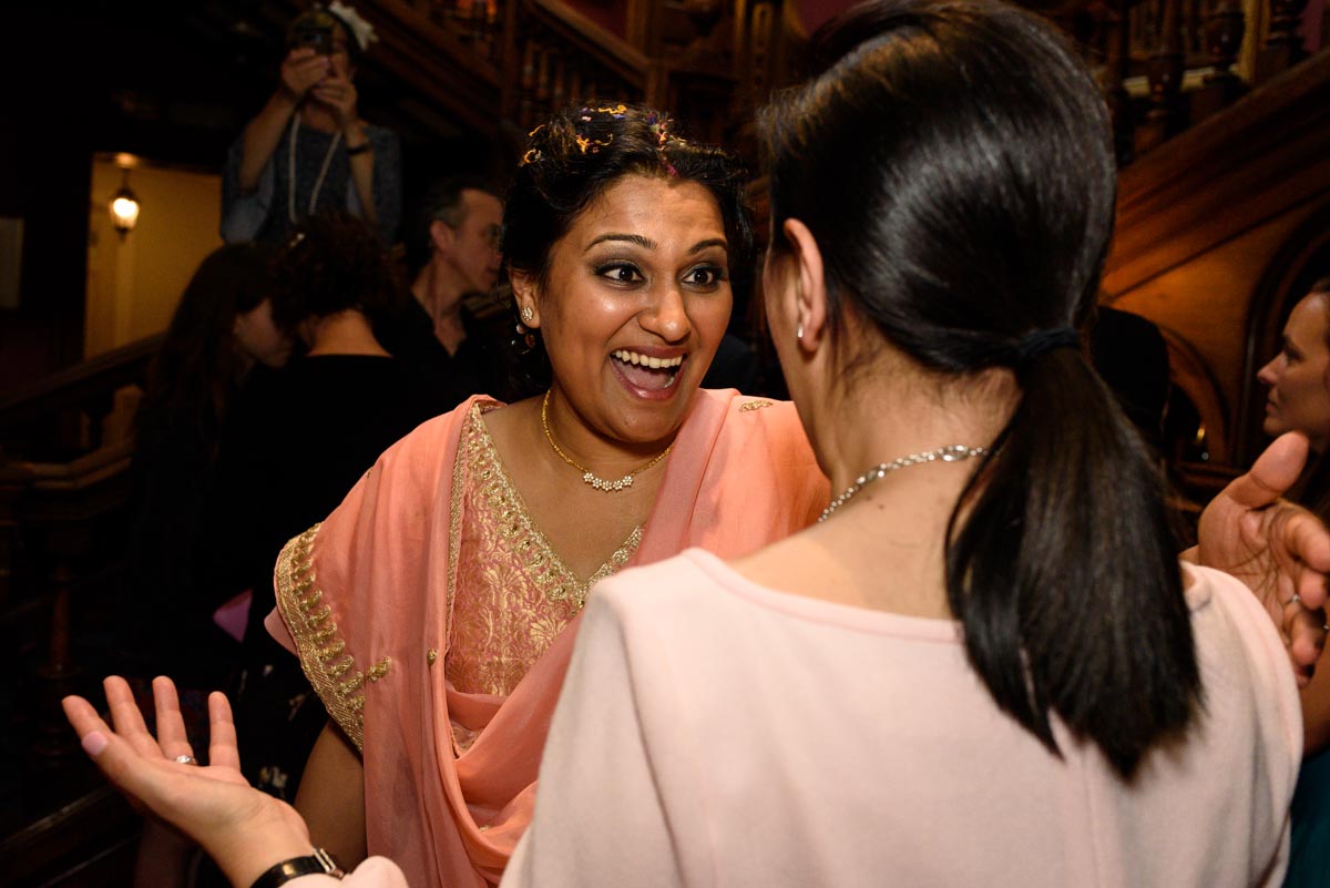 Vinita photographed laughing with friend at her wedding in Kents Chilston park