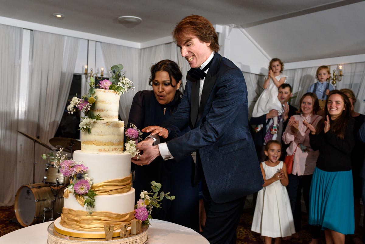 Doug and Vinita cutting their wedding cake at Chilston Park in Kent