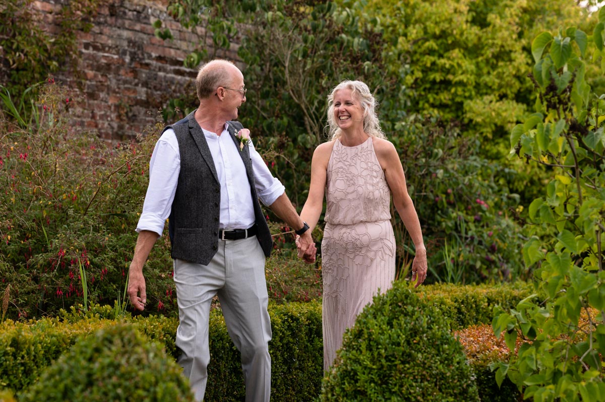 Jenny and Phil walk in the gardens at Kents Secret garden wedding venue in Kent