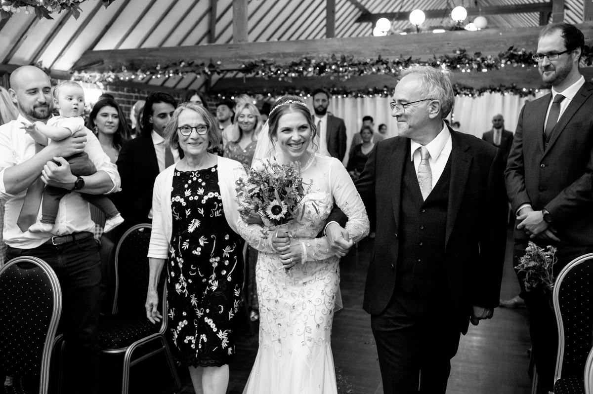 wedding photography best of 2021 photograph of bride and parents walking down the aisle at the hop farm in kent