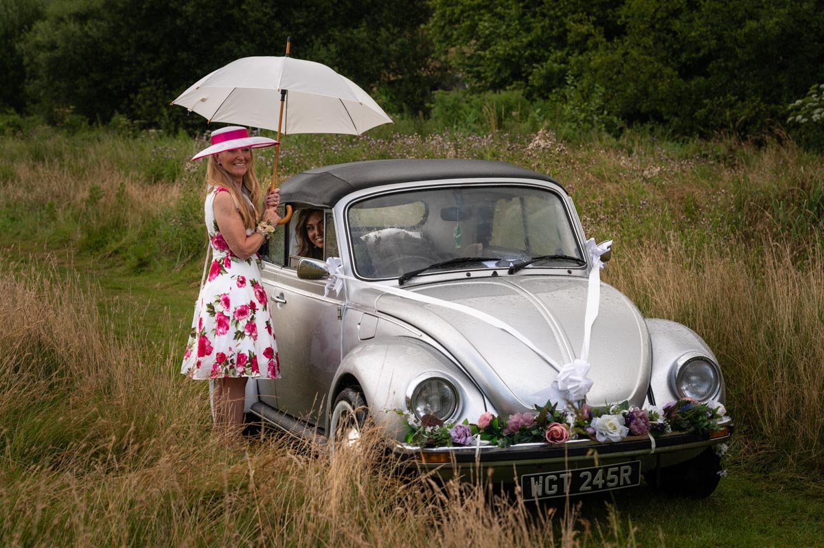 wedding photography best of 2021 mum and bride wait for rain to stop before kent wedding ceremony at wilderness venue in kent