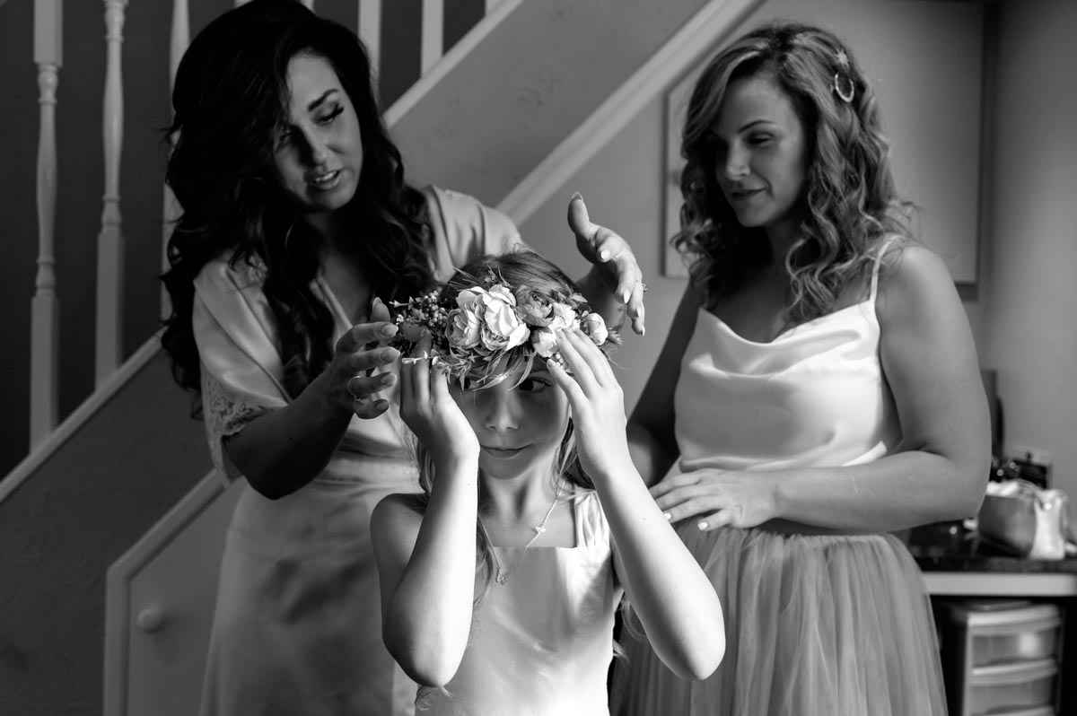 wedding photography best of 2021 black and white wedding photo of bride putting flower headdress on flower girl