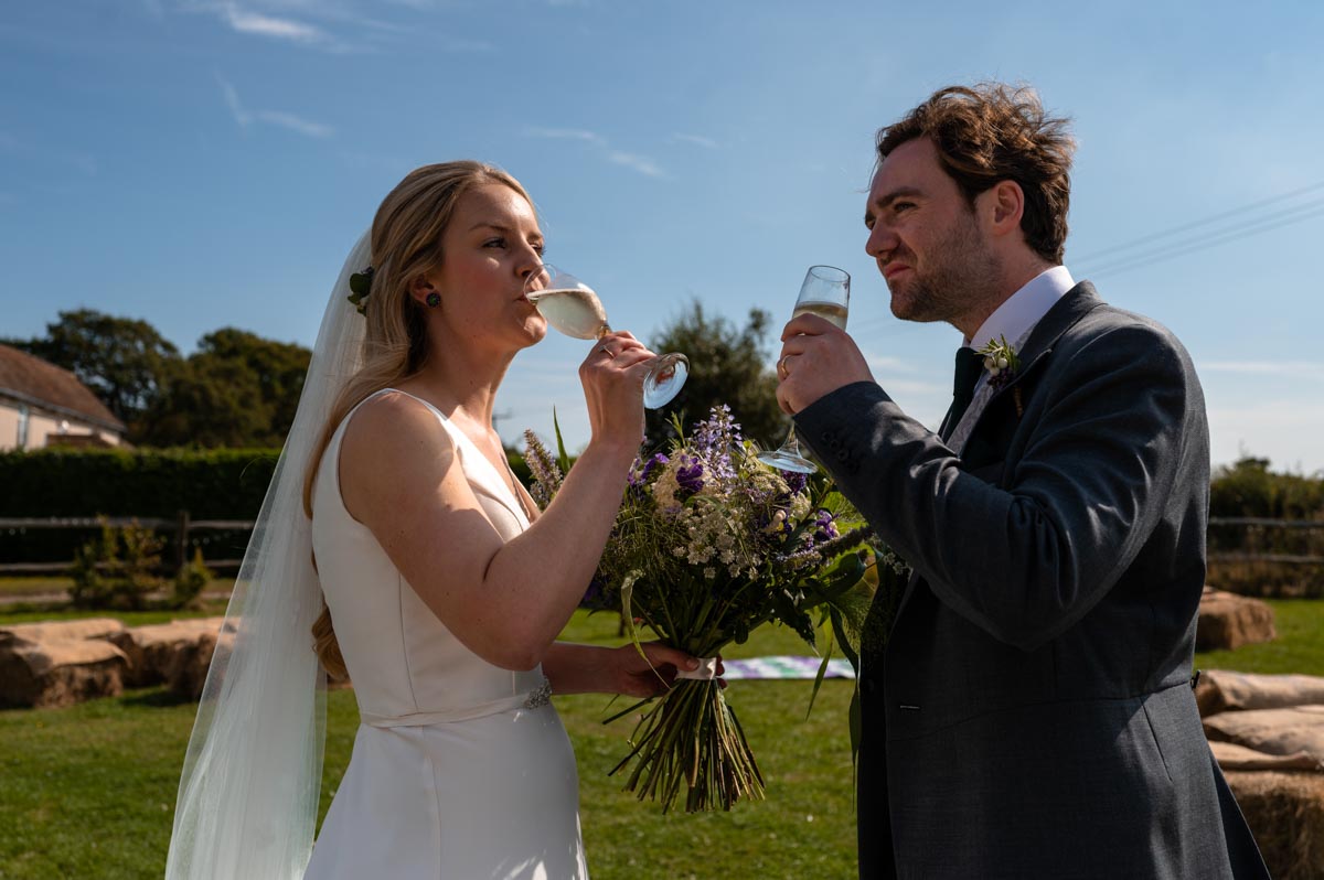 Fiona and Chris enjoy champagne after their Cherry barn wedding ceremony