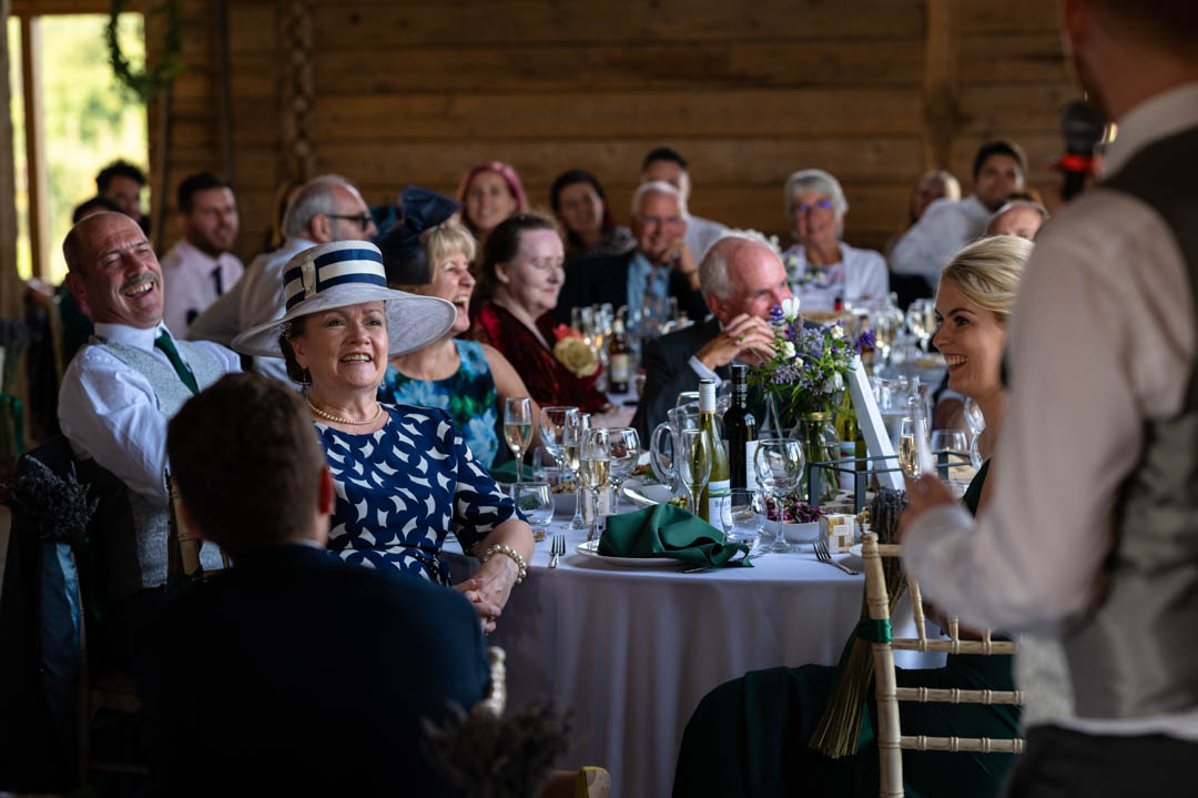 Photograph of wedding guests at Fiona and Chris's wedding during the speeches in The Cherry Barn