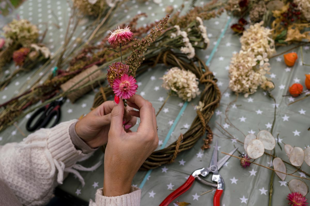 participant photographed making a dried flower wreath during day in the life photoraphy for business photoshoot