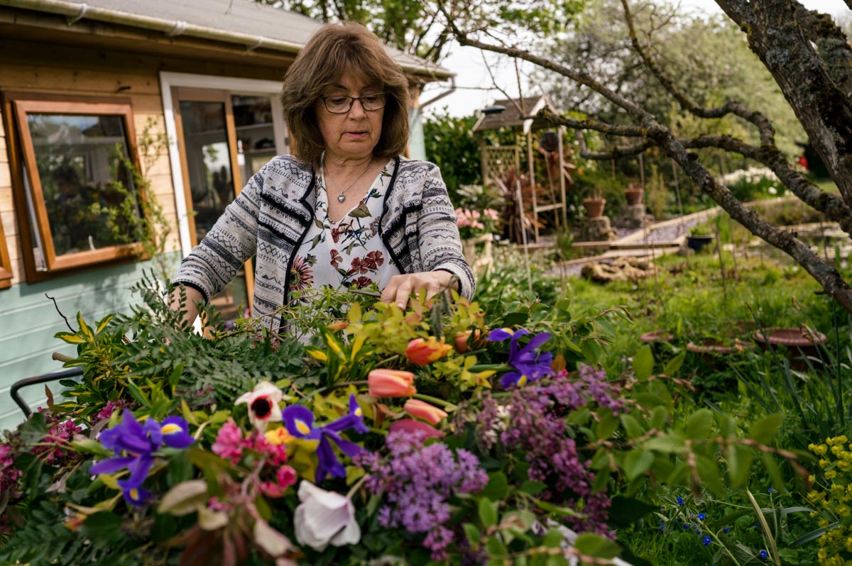 Photograph of Lin, owner of woodchurch cottage flowers putting together bouquet