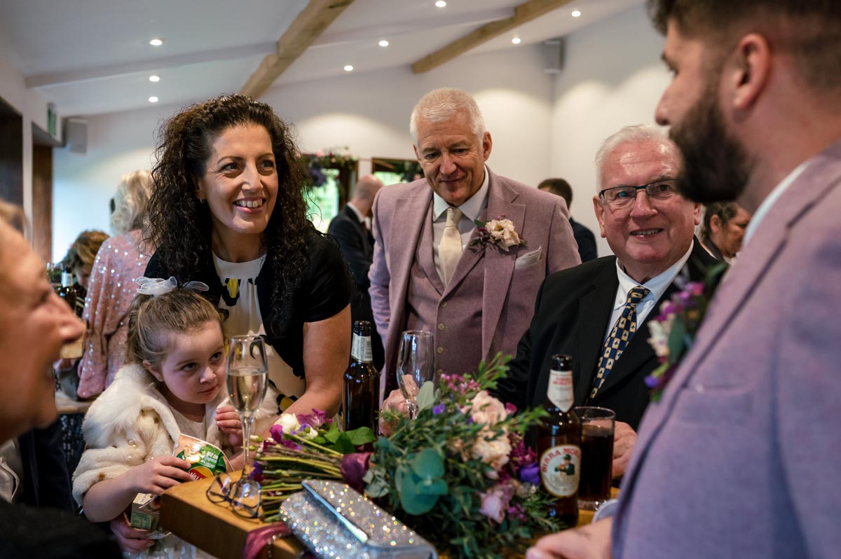 Wedding guests photographed during Will and Sophias reception at The Oak Barn, Frame Farm venue