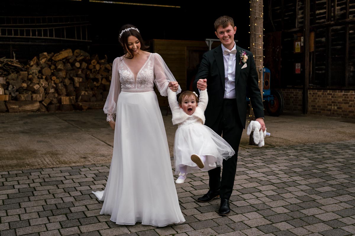 Photograph of Sophia and Will with daughter after their wedding at The Oak barn, Frame Farm in Kent