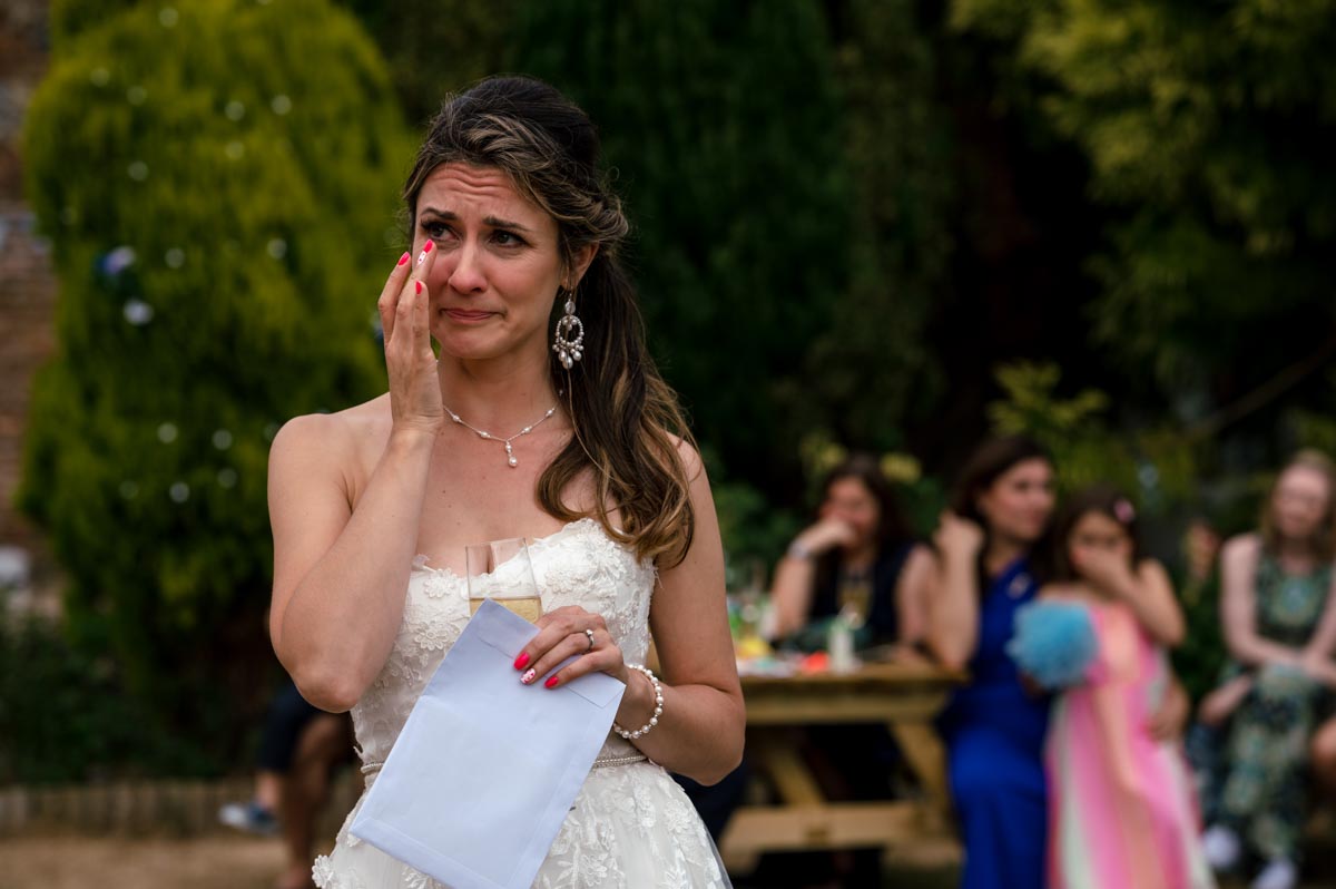 Natural wedding photography. Bride sheds a tear during speeches