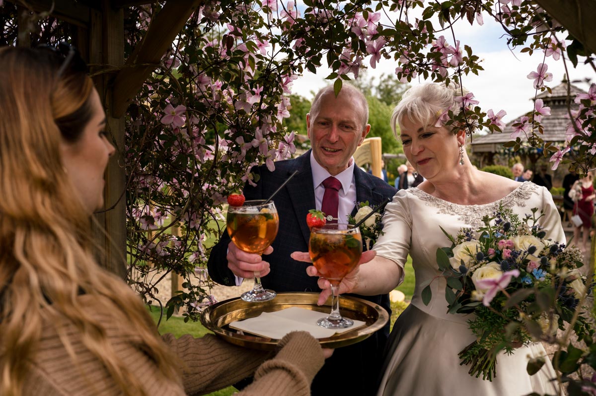 the secret garden wedding photography. bride and groom enjoy glass of pimms after outdoor ceremony
