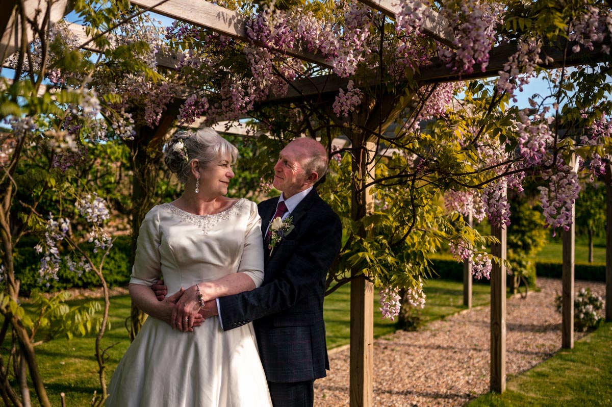 wedding photography at the secret garden in kent. Rachel and Tony portrait by the wisteria