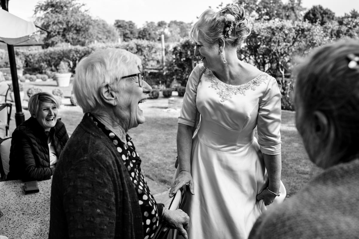 guest and bride photographed laughing during wedding reception at the secret garden in kent