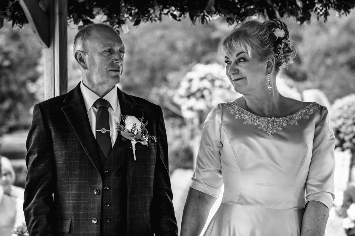 Tony and his bride share a glance during their wedding at the secret garden in ashford