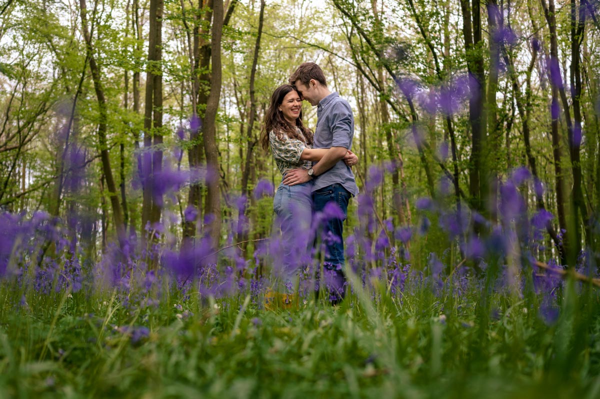 Photograph of Becca and Fred standing among the bluebells during their pre wedding photoshoot 