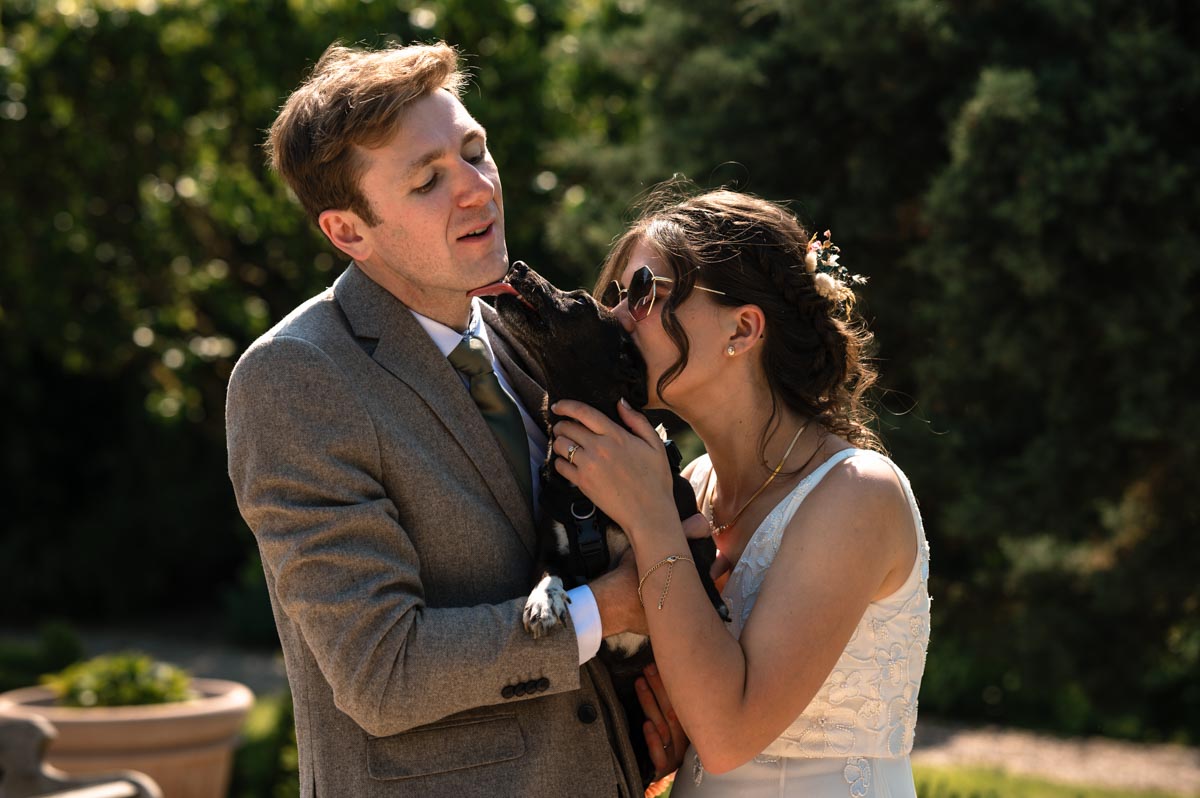 photograph of becca and fred with their dog at their wedding at the secret garden in kent