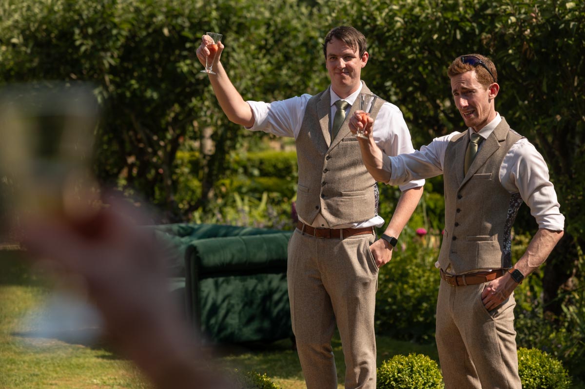 best men photographed toasting bride and groom at secret garden wedding in kent