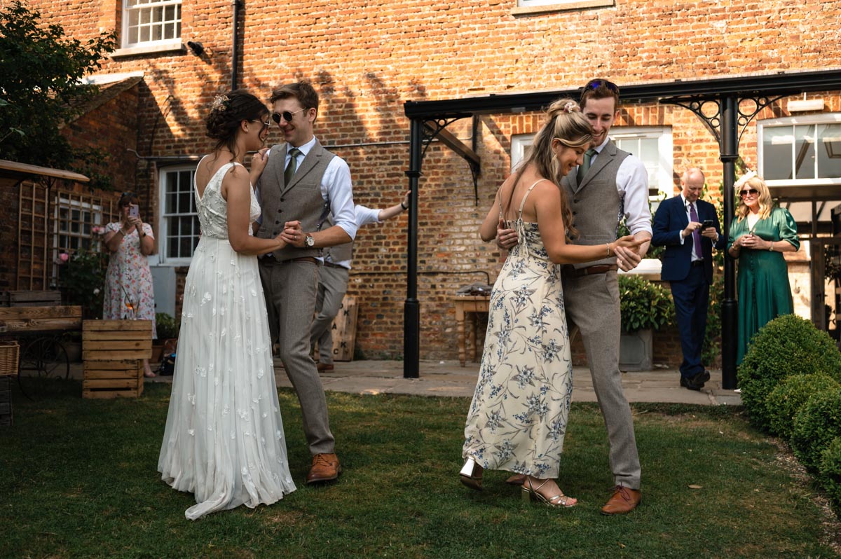 couple and guests photographed dancing at the secret garden wedding venue in kent