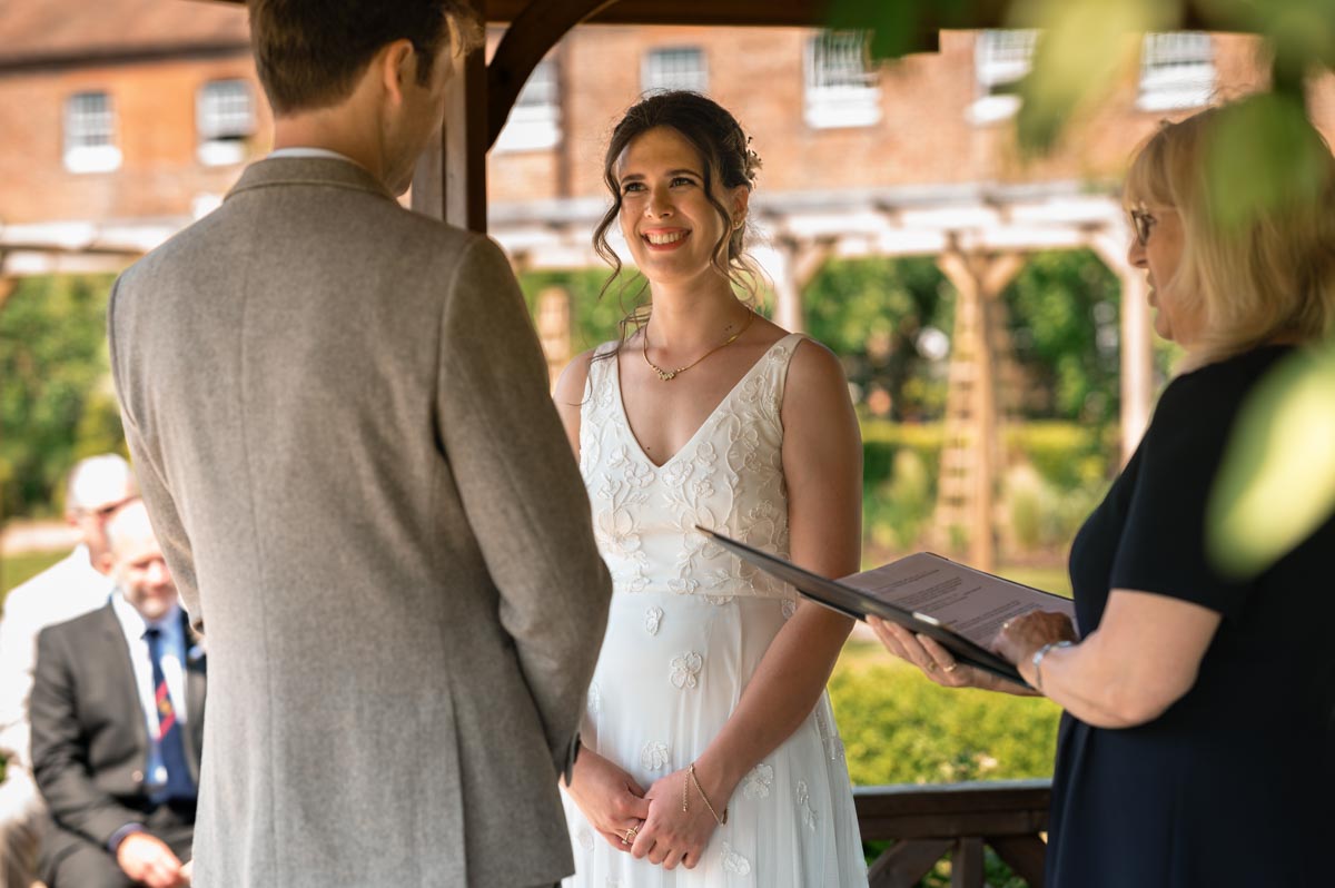 becca and fred photographed during their ceremony in the gazebo at the secret garden in kent