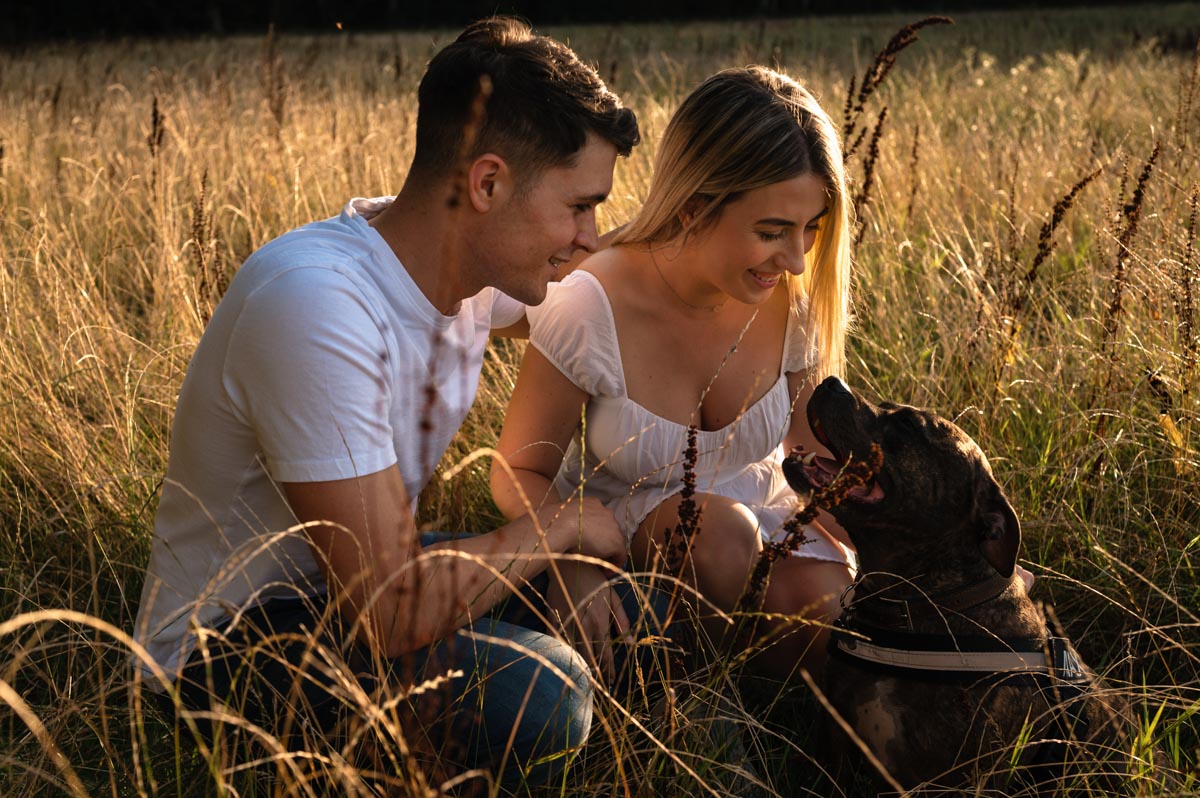 photo of sarah, james and their dog max during their golden hour pre wedding photoshoot