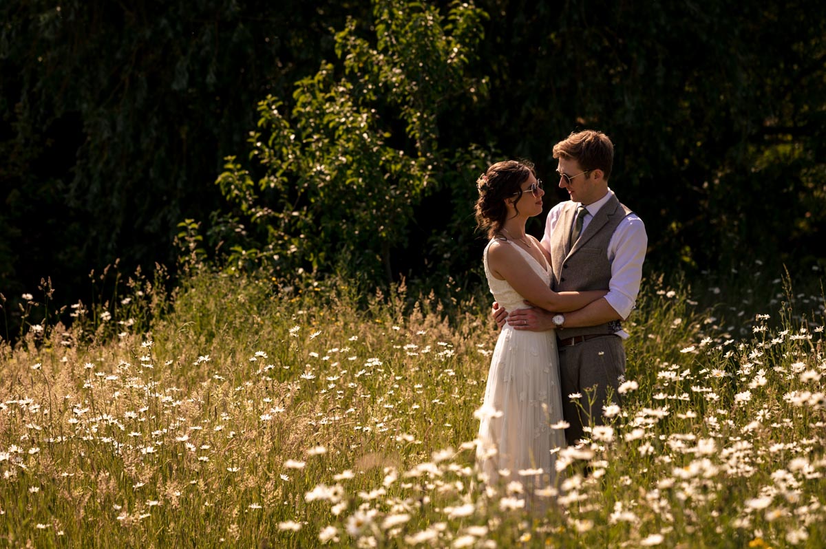 Fred and Becca photographed on their wedding day in the wild flowers at the secret garden kent
